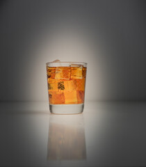 Glass of iced tea backlit on dark grey background