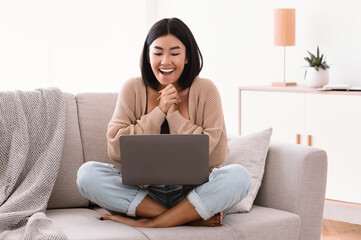 Fototapeta premium Excited young female feeling ecstatic using laptop