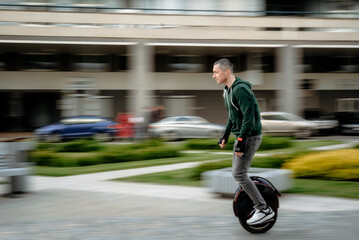 Man riding unicycle on street - 383296048