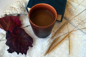 Ceramic coffee mug,  old book and dry ears of wheat. Autumn layout.