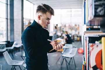 Trendy student taking note on clipboard sheet in library