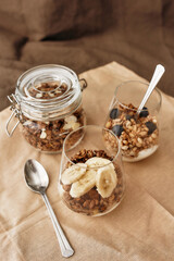 Close up of delicious layered dessert in glass jar, Homemade yogurt with granola and berries, Granola baked with nuts and honey