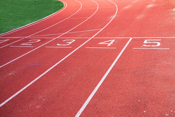 Athletic running track in a stadium with start point positions numbers one two, three, four five. No people.