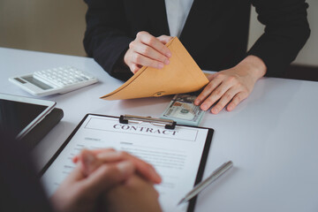 Business woman offering dirty money, cash under prepared envelope to bribe male officer for intercompany contract signing, cash bribery idea. For document signing