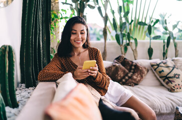 Happy woman having break and checking messages on smartphone