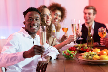 Joyful Multiethnic Friends Celebrating Christmas Drinking Champagne At Home