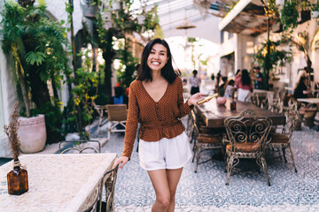 Smiling ethnic lady standing in cafe