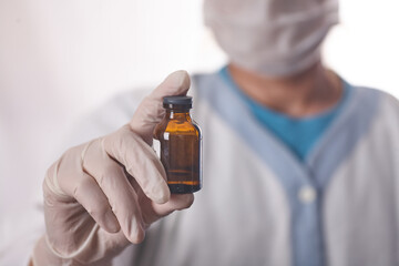 Doctor holds in his hands the drip with the drug.