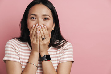 Photo of happy beautiful asian woman covering her mouth