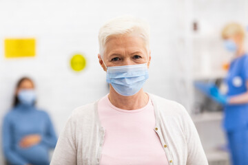 Fototapeta na wymiar Senior Patient Infected With Coronavirus Wearing Mask Posing In Hospital