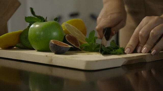 Woman cutting mint on the table