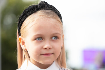 Blue-eyed little girl close-up. A child of elementary age.