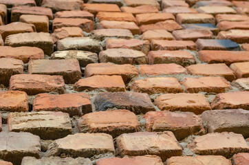 Red brick wall in receding perspective. Geometric composition of rectangular clay bricks.