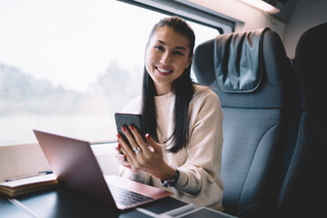 Fototapeta na wymiar Young woman sitting in front of laptop in train