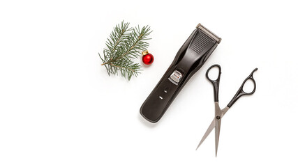Christmas composition. Hairdressing scissors, clipper and spruce branch on a white background. Template for a postcard or information about a hair salon. Flat lay, copy space.