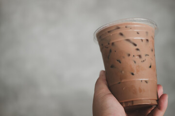 Man holding plastic glass of iced Mocha coffee