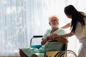 Eldery in wheelchair with nurse. An old man in a hospital, a nurse talking, encouraging, caring for...
