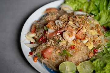 Fototapeta Spicy vermicelli salad with seafood, fresh vegetables.(Thai called Yum Woon Sen). obraz