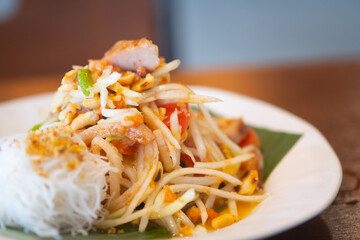 Thai spicy green papaya salad mix grilled pork neck served with rice vermicelli