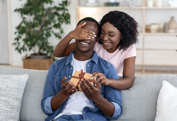 African woman giving gift box to her man