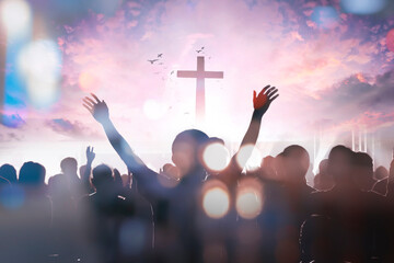 christian people group raise hands up worship God Jesus Christ together on cross over cloudy sky...