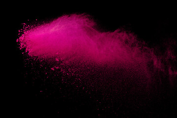 Pink powder explosion on black background. Colored cloud. Colorful dust explode. Paint Holi.