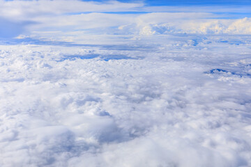 Naklejka premium Clouds and sky as seen through window of an aircraft.