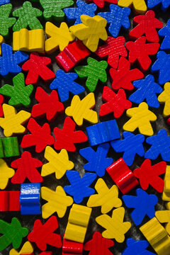 many bright multi colored wooden meeples