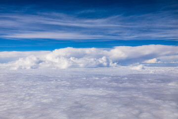 Clouds and sky as seen through window of an aircraft.