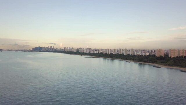 Aerial shot of Singapore coastline with ships and city in background