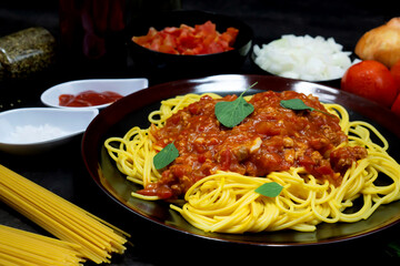 Tasty appetizing classic italian spaghetti pasta with tomato sauce, cheese parmesan and basil on plate on dark table. ,Select Focus