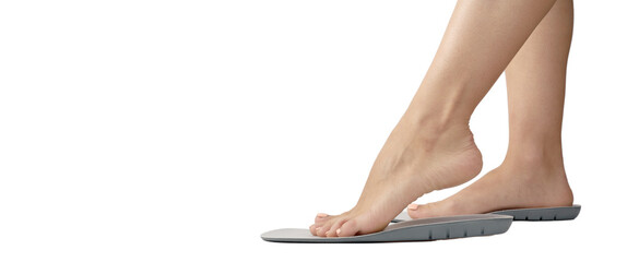 Beautiful female feets and insoles isolated on a white background. The girl tries on orthopedic...