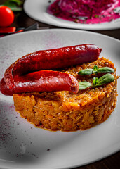 Fried cabbage with sausage in white plate