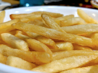 A white plate full of delicious french fries macro isolated snack side view closeup