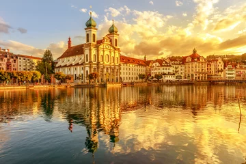 Deurstickers Amazing colorful sunset city center of Lucerne of Lake Lucerne in Central Switzerland. Jesuitenkirche or Jesuit Church of St. Francis Xavier reflects on Reuss river. Famous landmark of historical city © bennymarty