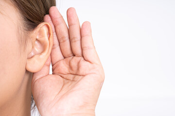 woman hearing loss or hard of hearing and cupping her hand behind her ear isolate on white background, Deaf concept. - obrazy, fototapety, plakaty