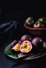 Fresh ripe passion fruits (maracuyas) on dark background with water drops