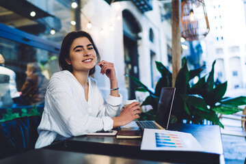 Smiling woman drinking coffee in cafe