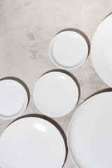 set of clean white plates on white background, vertical