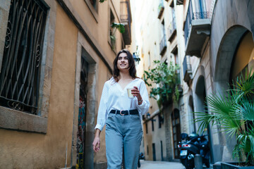 Obraz na płótnie Canvas Cheerful woman enjoying coffee during walk