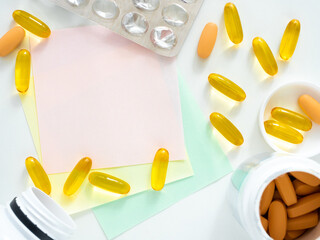 Empty stickers for filling out a prescription for pills and a lot of capsules on the table, top view, flat layout. Pharmaceutical concept for medicine with space for text. Reminder of a daily pill