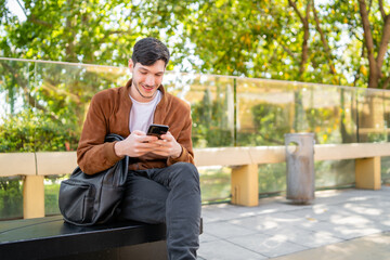 Fototapeta premium Young man using his phone outdoors.