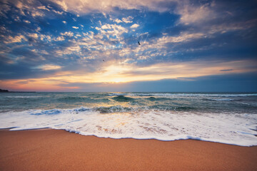 Ocean beach sunrise and dramatic colorful sky clouds