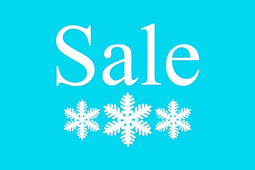 Sale and white snowflakes on a blue background, top view. Background for Christmas, new year, and winter sales. Seasonal discounts in stores. Final sale, purchase concept, banner for stores