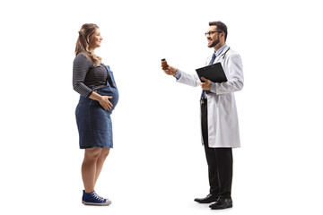 Full length profile shot of a doctor giving a bottle of vitamin pills to a pregnant woman