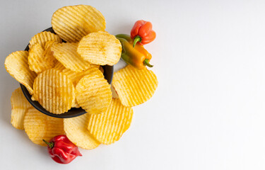 Homemade hot chips with jalapeno peppers on the side . Isolated on a white background .