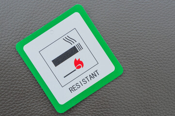 Fire resistant sign on grey leather sofa.