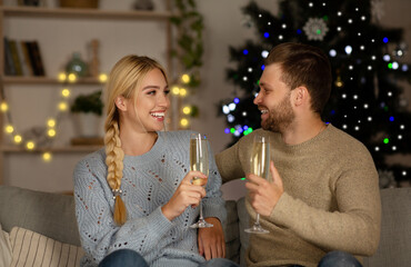 Happy man and woman drinking champagne at home