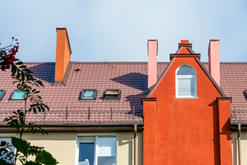 Exterior of the facade of a residential building with a beautiful roof and dormers, attic light....
