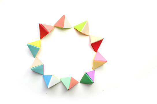 A circle of tetrahedrons origami objects on white